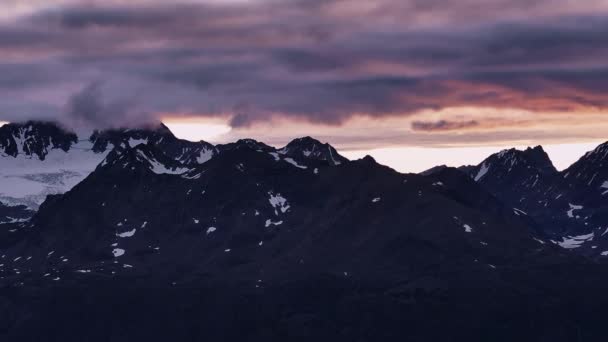 日没の空を背景に雪山をドローン飛行する — ストック動画