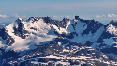 Soğuk bir kış gününde Kuzey yabanda kar kaplı bir dağ sırasının çarpıcı hava manzarası. 4K Hava Videosu.