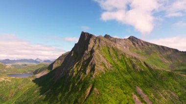 Arka planda Norveç denizi olan görkemli yeşil kayalık fiyortların güzel manzarası. Lofoten Adaları.