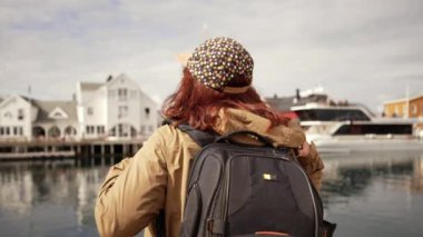 Sırtında sırt çantası olan bir turist Norveç 'teki fjord' a hayran. Aktif yaşam tarzı ve seyahat