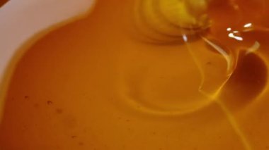 Beyaz arka planda bal damlayan bal damlası, sarı ton