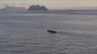 Karla kaplı dağları, Lofoten 'ı, Norveç' i, 4k insansız hava aracını okyanustaki yalnız teknenin görüntüsü.