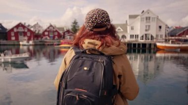 Sırtında sırt çantası olan bir turist Norveç 'teki fjord' a hayran. Aktif yaşam tarzı ve seyahat