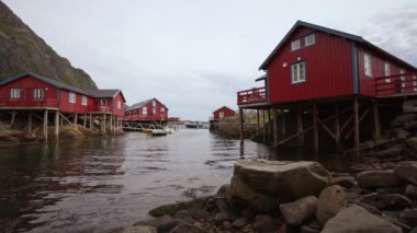 tipik kırmızı rorbu kulübe sod çatı içinde Norveç Fiyordu içinde yansıtan lofoten Adaları ile Balık tutma