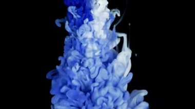 Renkli boyalı üst görüntü yavaş çekimde suda karışıyor. Siyah arkaplanda mürekkep sıvısı var. kırmızı mavi sarı soyutlama