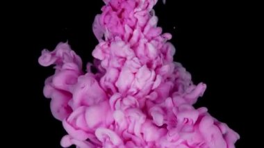 Pembe ve beyaz akrilik mürekkep siyah arka planda suya karışıyor. Soyut çok renkli arkaplan