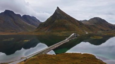 Lofoten adalarındaki köprüden geçen bir arabanın robot resmi, arka planda dağlar, güneşli, sonbahar günü Nordland, Kuzey Norveç 'te - doli, hava manzaralı
