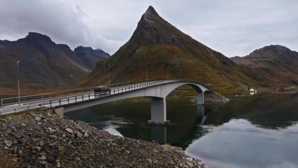 在挪威北部的诺德兰 秋天阳光灿烂的一天 无人驾驶汽车驶过洛福顿岛的一座桥 背景是群山 无人机拍到了无人驾驶汽车的镜头 — 图库视频影像