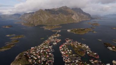 Henningsvaer Limanı, güneşli bir günde mavi gökyüzü ve yansıyan su, geriye dönük hava çekimi, Lofoten, Norveç