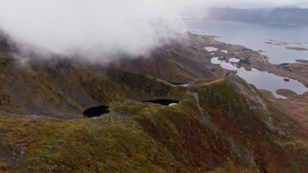 急な岩山の空中ビュー 海から上昇 ノルウェーのロフテンで秋の日 ドローンショット — ストック動画