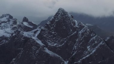 Norveç 'in deniz suyuna yansıyan beyaz karla kaplı yüksek dağlık kayalık tepelerin nefes kesici kuşları bakışı görüntüsü. Senja 'nın kışın nefes kesici panoramik fiyortları, doğanın sakin güzelliği..