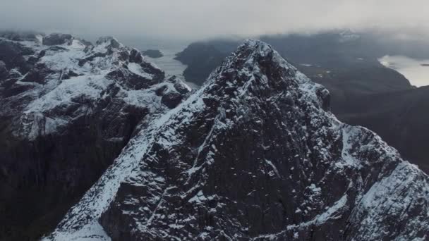 ノルウェーの海水に映し出された白い雪で覆われた高い山の岩の山の頂上の息をのむような鳥の視界 冬のセナヤのパノラマフィヨルドの風景を眺める 自然の穏やかな美しさ — ストック動画