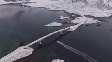 Arktik Lofoten Adaları 'nın muhteşem hava aracı görüntüleri. Kış harikalar diyarı. Güzel, güneşli bir günde köprüden geçen araba manzarası..