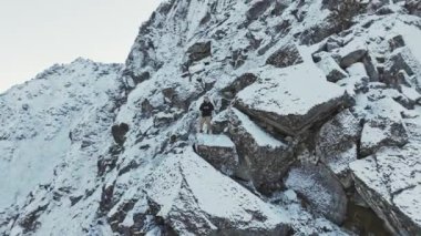 Soğuk bir kış gününde, karla kaplı dağ zirvesi mavi gökyüzü ve kabarık bulutlarla dolu. Kışın Bitihorn Dağı.