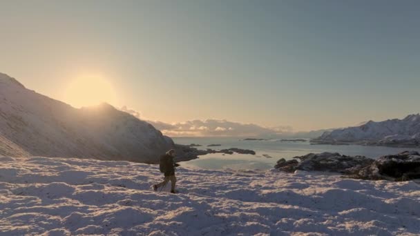 登山コンセプトの山頂に登るバックパック付きのハイカー 雪を歩く男 冬にハイキングする 冒険のトレッキング 自然の概念の人々 エピックサンセットビュー雪山景観 — ストック動画