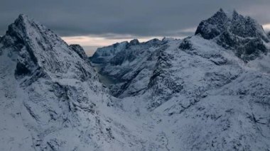 Soğuk bir kış gününde Kuzey yabanda kar kaplı bir dağ sırasının çarpıcı hava manzarası. 4K Hava Videosu.