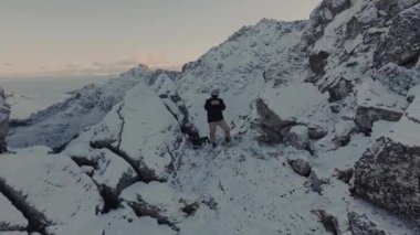 Soğuk bir kış gününde, karla kaplı dağ zirvesi mavi gökyüzü ve kabarık bulutlarla dolu. Kışın Bitihorn Dağı.