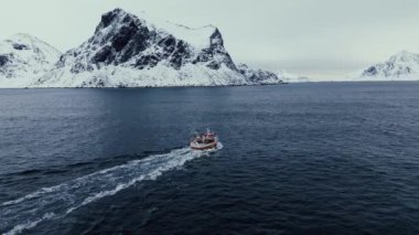 Kuzey Avrupa 'da Kuzey Kutup Dairesi, İskandinavya' da güzel soğuk bir kış gününde geleneksel balıkçı teknesinin açık okyanusa açılmasının ardından inanılmaz bir hava aracı görüntüsü geliyor.