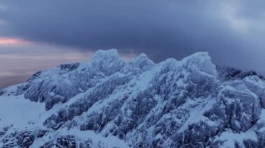 Norveç 'in deniz suyuna yansıyan beyaz karla kaplı yüksek dağlık kayalık tepelerin nefes kesici kuşları bakışı görüntüsü. Kışın Lofoten 'in nefes kesici panoramik fiyortları, doğanın sakin güzelliği.