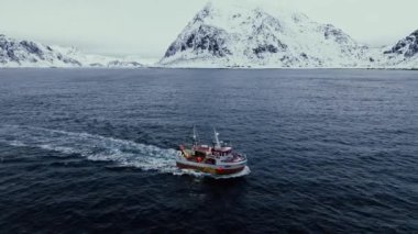 Kuzey Avrupa 'da Kuzey Kutup Dairesi, İskandinavya' da güzel soğuk bir kış gününde geleneksel balıkçı teknesinin açık okyanusa açılmasının ardından inanılmaz bir hava aracı görüntüsü geliyor.
