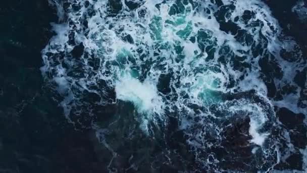 海のカラフルな水は 岩や風光明媚な海岸線の周りを旋回 岩を破る海の波 — ストック動画