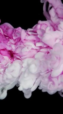 Pembe ve beyaz akrilik boya gri bir zemine karşı suda birbirine çarpar, renkli mürekkep renkli bir bulut gibi yayılır ve patlar, floresan ışık ve doğal parıltı gibi. Yavaş çekim