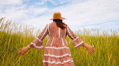 Huzurlu bir anda, bir kadın yemyeşil bir alanda doğanın nefes kesici güzelliğinden derinden zevk alır.