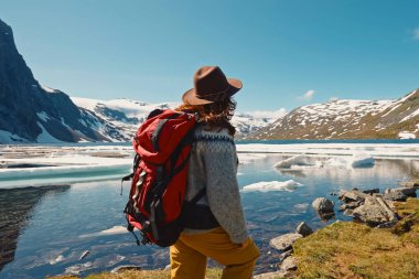 Kendini adamış bir gezgin, berrak mavi gökyüzünün altındaki buzlu suların ve görkemli dağların nefes kesici manzarasından zevk alır.