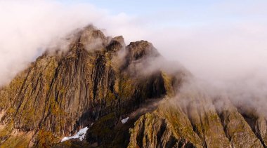 Gökyüzünde dramatik tepeler ve yumuşak, dalgalı bulutlar barındıran kesinlikle çarpıcı bir dağ manzarası