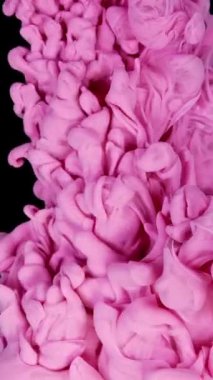 Büyüleyici ve büyüleyici bir karışım. Pembe duman zarif bir şekilde siyah bir zemine doğru kıvrılıyor.