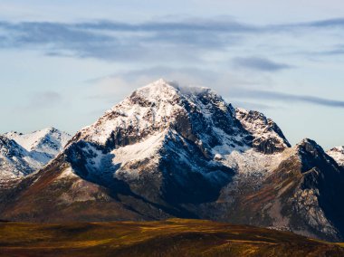 Görkemli kar örtülü bir dağın nefes kesici manzarası doğanın güzelliğini ve dinginliğini gözler önüne seriyor.
