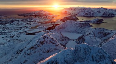 Karlı dağların ve sakin suların üzerindeki çarpıcı günbatımına tanık olun. İnanılmaz cazibeli doğalar sergiliyor.