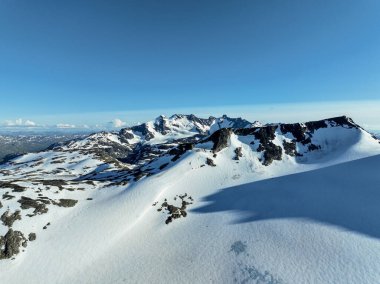 Gerçekten çarpıcı bir manzara, el değmemiş, el değmemiş bir dağ manzarasında yüksek karlı tepeler ve engebeli araziler sergiliyor.