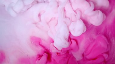 Suda çözünen pembe ve beyaz mürekkebin güzel ve soyut bir görüntüsü, yaratıcı projeler için ideal.