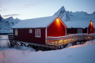 Büyüleyici kırmızı kamaralar Karla kaplı dağların arasında güzel bir şekilde yuvalanmış akşamın büyüleyici alacakaranlığında
