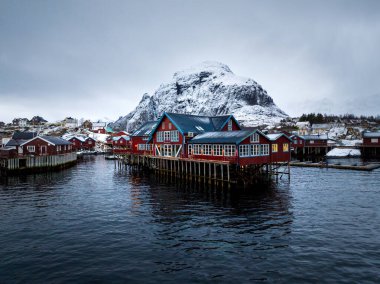 Göz kamaştırıcı kırmızı kulübeler, Norveç 'in çarpıcı bir dağ zeminine kurulmuş parıldayan sularla iç içe.