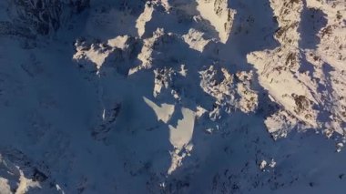 Çarpıcı hava görüntüleri engebeli karlı dağ manzaraları ve çarpıcı doğal oluşumlar gösteriyor..