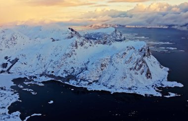 Nefes kesici hava manzarası karla kaplı dağlar ve buzlu sular gün batımında nefes kesici bir manzara.