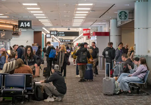 TORONTO, CANADA - 03 10 2024: Toronto Pearson Uluslararası Havaalanı 'nda kalabalık bir Terminal 3 terminalinde canlı sohbet yapan bir grup gezgin.