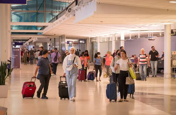 Montreal, Quebec, Kanada - 07 04 2022: Küçük valizli gezginler Montreal-Trudeau Uluslararası Havalimanı Uluslararası Terminali 'nin koridorunda yürüyorlar.
