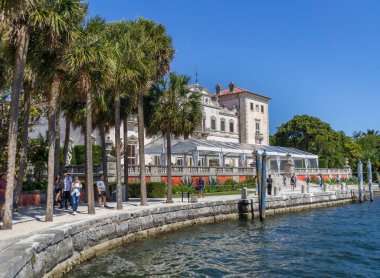 Miami, Florida, ABD - 03: 11 2024: Villa Vizcaya Müzesi 'nin güneşli öğlen manzarası Biscayne Körfezi' nin mavi sularının yanında gezinen ziyaretçilerle birlikte. Vizcaya Müzesi ve Bahçeleri