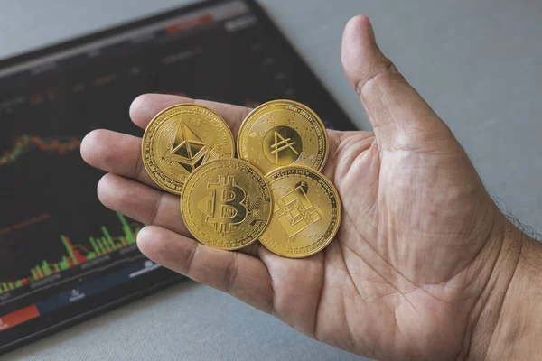 stock image Close-up hand of man holding crypto coin on chart in tablet background. Blockchain technology finance future. Male hold bitcoin. concept about business, finance, trade, economy, banking, investment.