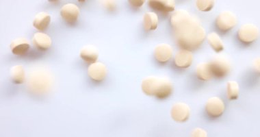 Yakın plan Top View - bir grup hap ve hafif turuncu uçakla stüdyoda kameraya doğru uçuyor. Sağlık için vitamin takviyesi. Uyuşturucu bağımlılığı. 4k çözünürlüğü.