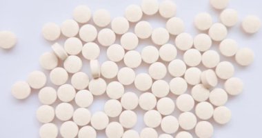 Yakın plan Top View - bir grup hap ve hafif turuncu uçakla stüdyoda kameraya doğru uçuyor. Sağlık için vitamin takviyesi. Uyuşturucu bağımlılığı. 4k çözünürlüğü.