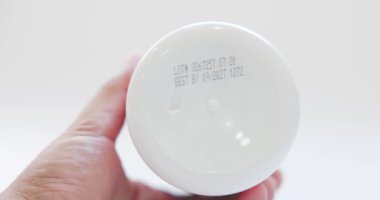 İlaç ya da vitamin şişesinin prodüksiyon tarihi ve son kullanma tarihi. Son kullanma tarihini okuyorum. Gıda güvenliği, gıda takviyesi, ilaç, sağlık, gıda güvenliği kavramı. 4k çözünürlüğü.