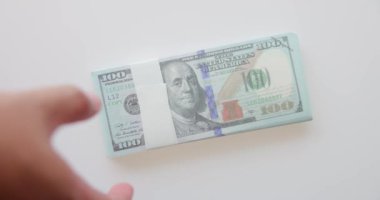 Adamın eli beyaz arka planda 100 dolarlık banknotları topluyor. Amerika Birleşik Devletleri Finans Yığını. Bankacılık, nakit, tasarruf, fiat para konsepti, 100 dolar. Para Mockup. 4K VDO.
