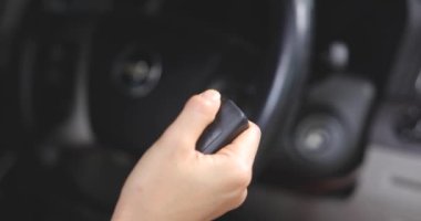 Görüntüyü kapatın. Bir kadın anahtarı elinde tutar ve motoru çalıştırmak için düğmeye basar ve ayrılmaya hazırlanır. VDO 4K çözünürlüğü. Araç, Seyahat, Güvenlik, Sürüş kavramı.