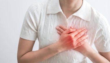 Kalp yetmezliği. Genç bir kadın, acı dolu bir ifadeyle göğsüne bastırıyor. Şiddetli kalp ağrısı, kalp krizi ya da ağrılı kramplar, kalp hastalığı. Kalp sorunu olan insanlar.