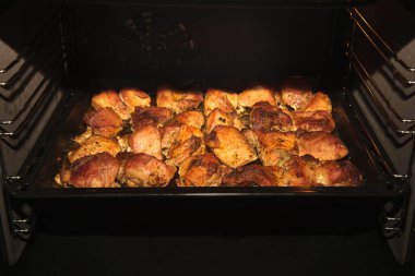 Grilled meat with various spices in an electric oven. Special lighting, clarity, good photo for advertising banners.