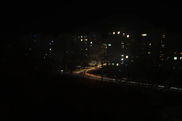 夜の街の灯 路上では街路灯が完全に消灯され 道路や歩道に沿って懐中電灯を備えた別々の車両や通行人だけが移動します — ストック写真